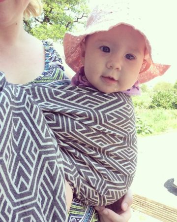 baby in hat in sling