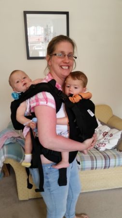 Twingo babycarrier with twins being carried by mum.