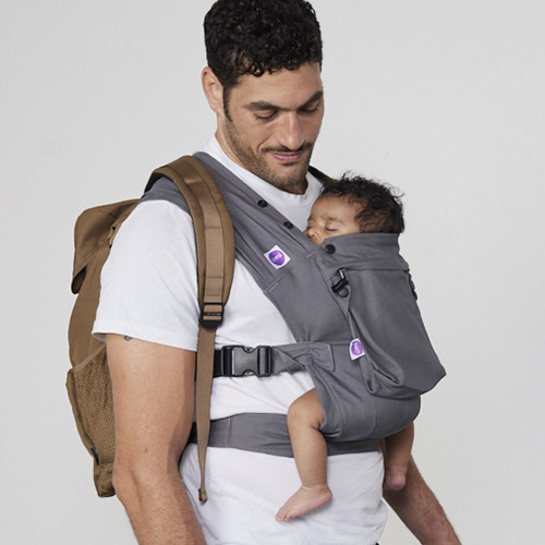 Man carries baby on his chest in Izmi Baby Carrier with Zip Pocket