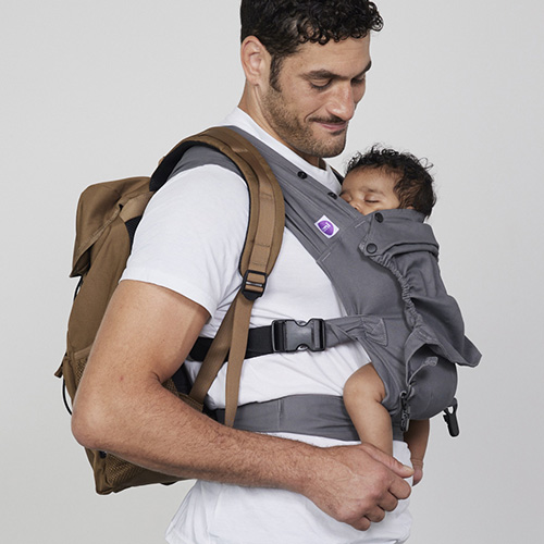 Man carries baby on his chest in Izmi Baby Carrier with Sleep Hood