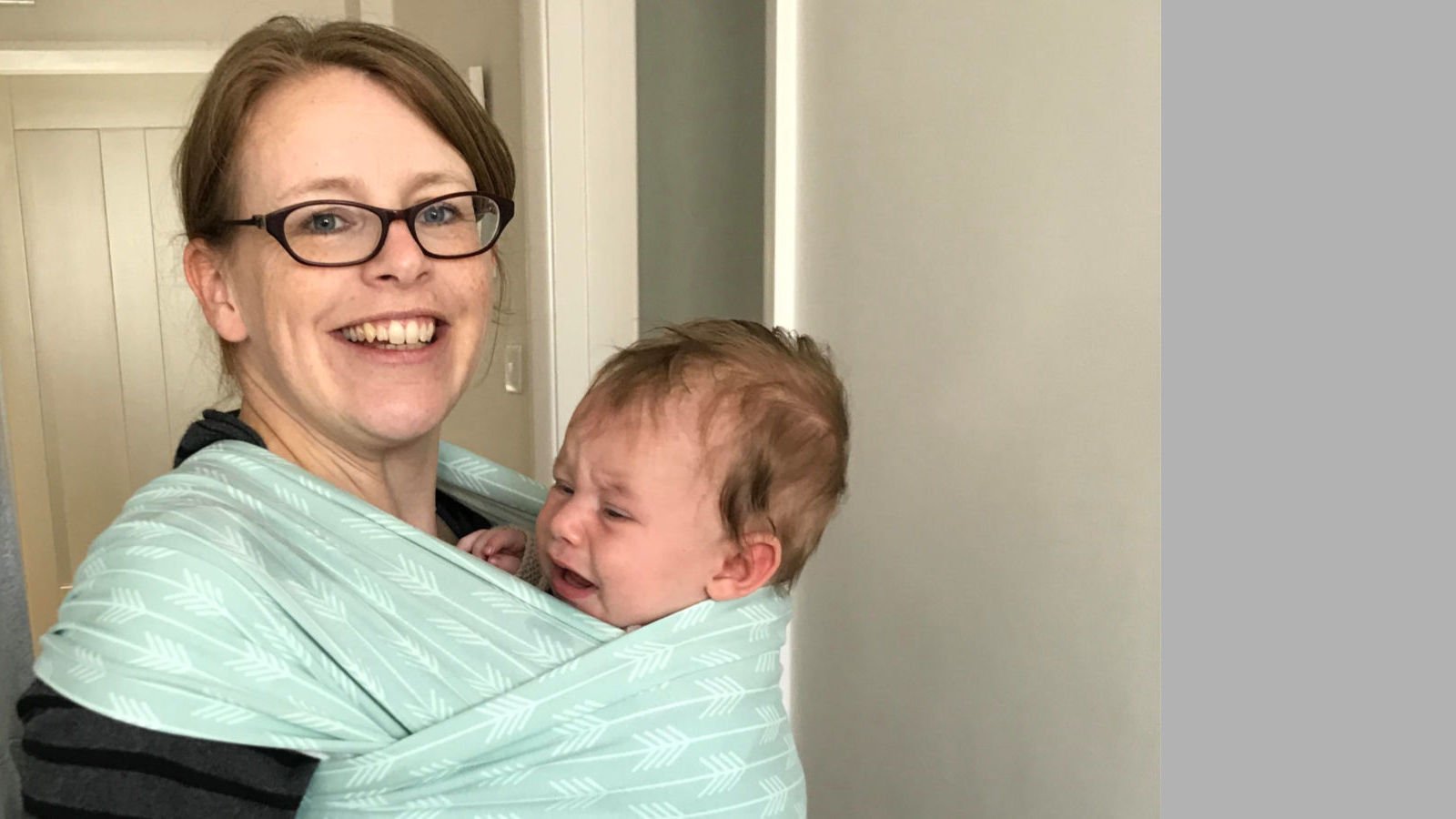 baby crying in a stretchy wrap sling