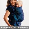 Woman carries toddler on her front in Lenny Lamb Preschool carrier in Peacock's Tail Provance fabric, side view