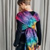 Back view of woman carrying baby in Lenny Lamb Wrap Tai baby carrier in colourful dinosaur print Jurassic Park New Era fabric