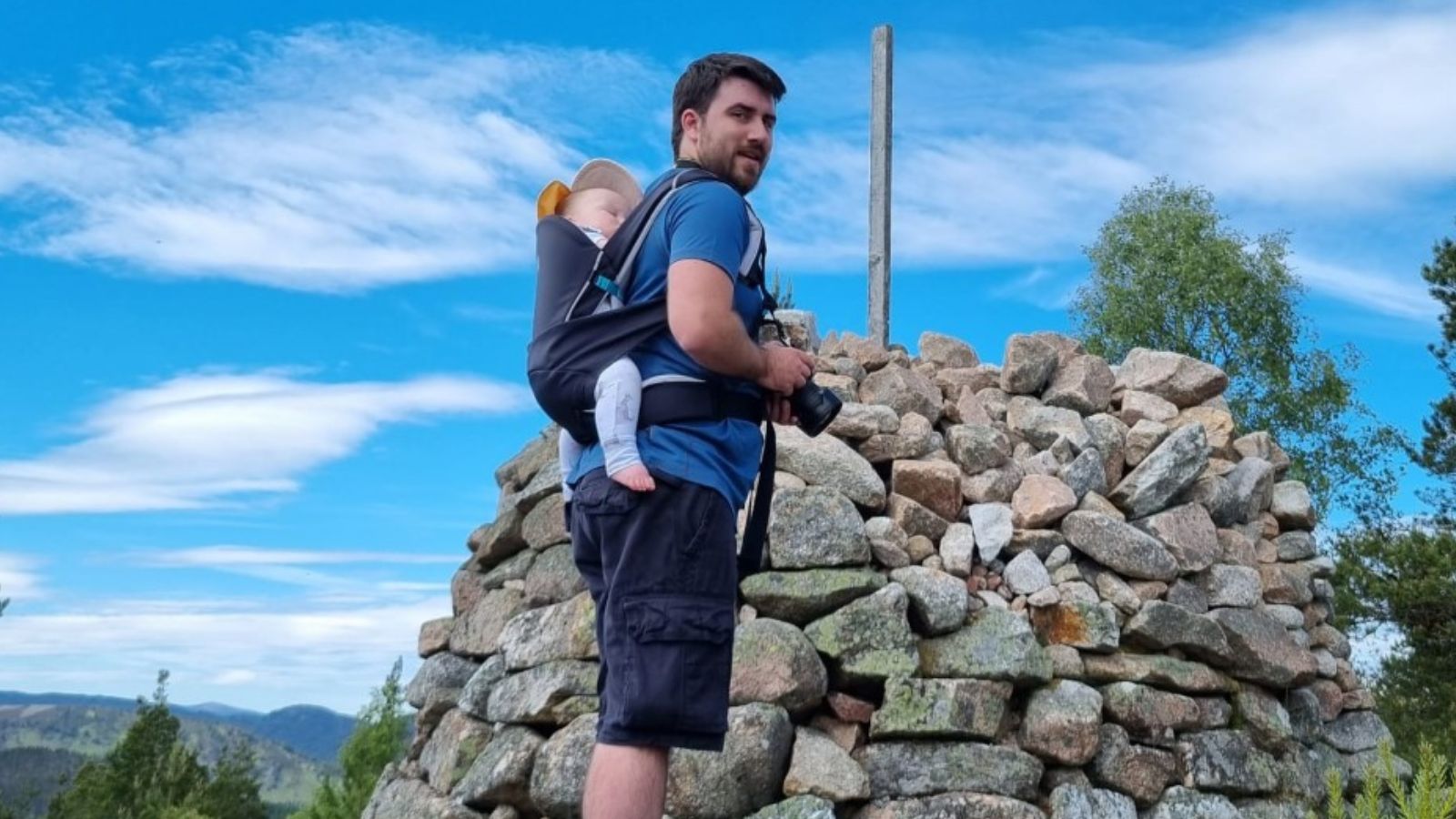 Man carrying baby on his back in Cococho baby carrier
