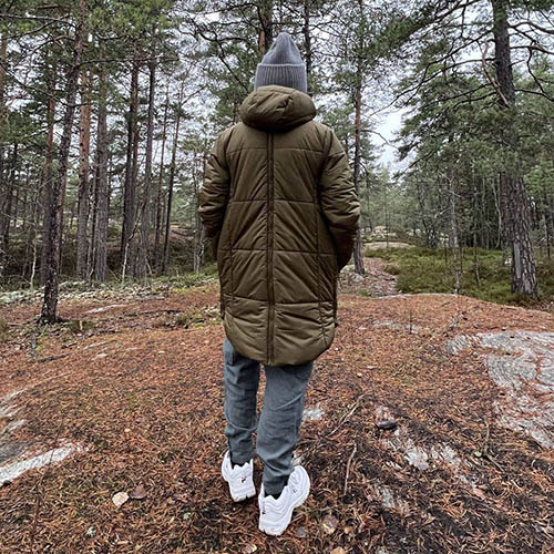 Back view of woman wearing the Mamalila Copenhagen babywearing coat in khaki