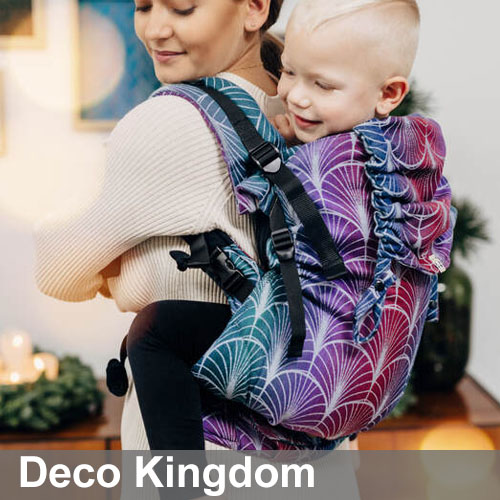 Woman carries toddler on her back in Lenny Lamb Preschool carrier in colourful Deco Kingdom fabric