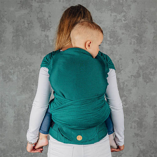 Woman carries toddler on her back in Lenny Lamb LennyHybrid Preschool toddler carrier in Emerald, back view