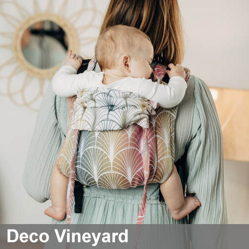 Woman carries baby on her back in Lenny Lamb Onbuhimo carrier in colourful Deco Vineyard fabric, back view