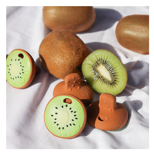 Kiwi shaped rubber teething toy by Oli & Carol pictured with real kiwi fruits