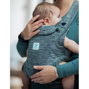 Woman carries baby facing towards her chest in the Carifit+ baby carrier