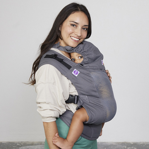 Woman carries toddler on her front in Izmi Breeze Toddler Carrier with Sleep Hood