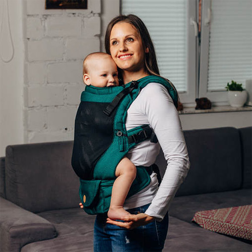Side view of woman carrying baby facing towards her in Lenny Lamb LennyUpgrade mesh baby carrier in Emerald green fabric